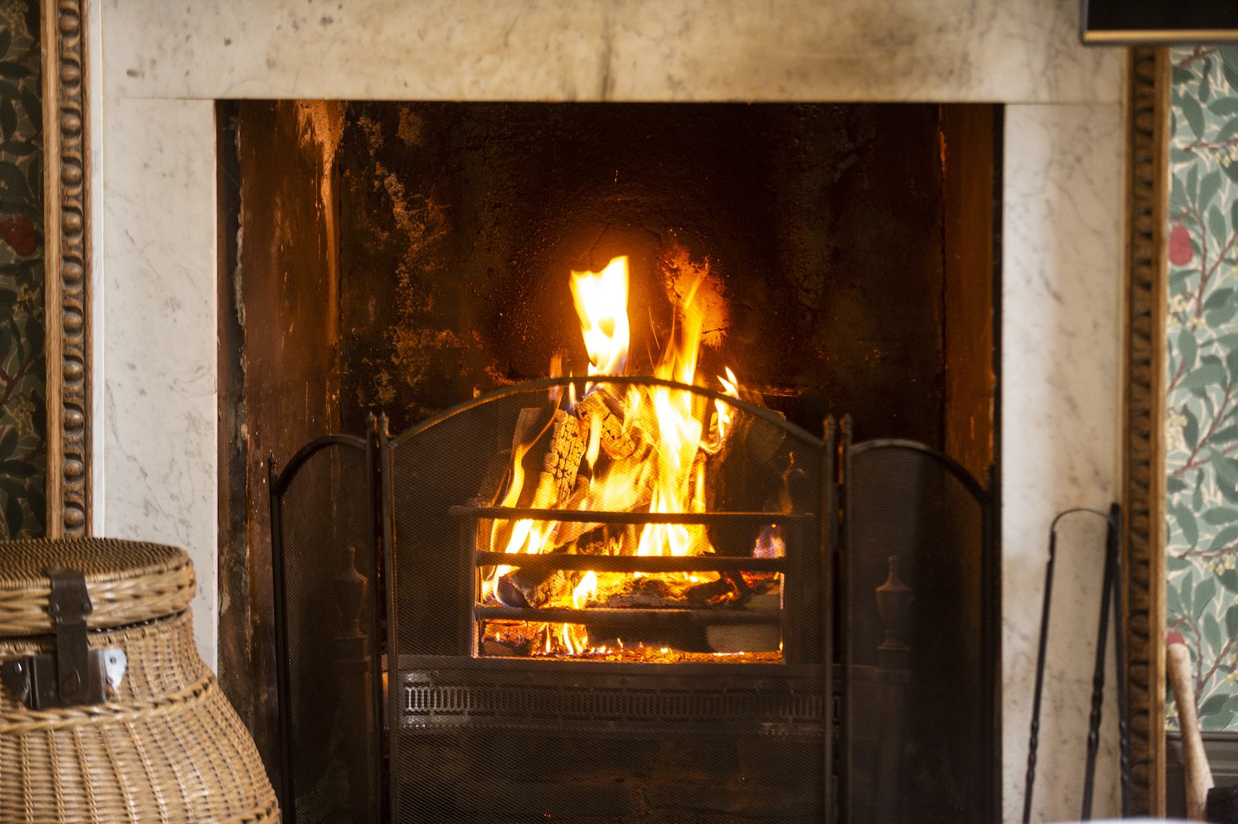 A cosy seating area beside the open log fire at Rock House